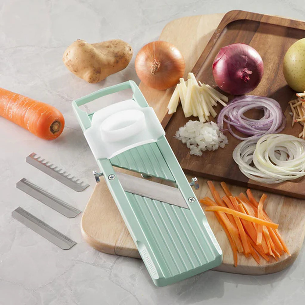 Mandoline slicers always available at Chef's Hat Mandoline slicer with julienned carrot, onion, and potato on a chopping board